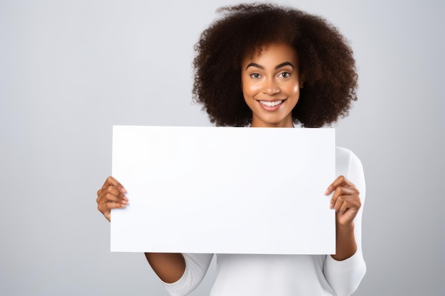 Une jeune femme noire heureuse tenant un panneau blanc blanc signe portrait de studio isolé