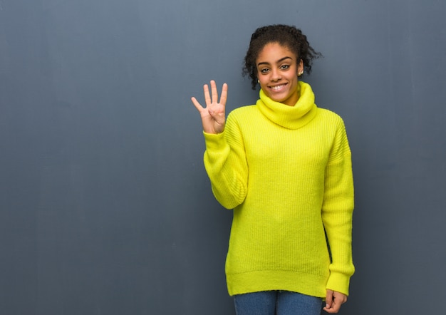 Jeune femme noire montrant le numéro quatre