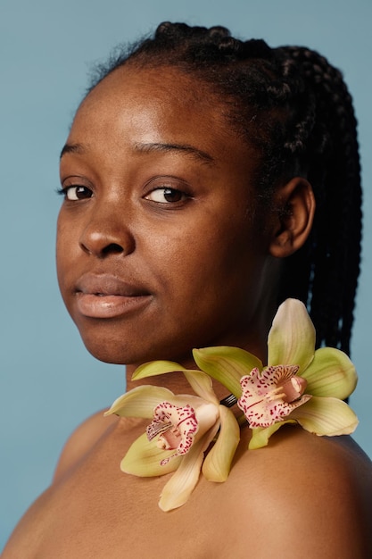 Une jeune femme noire avec des orchidées