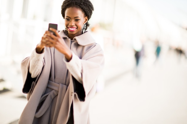 Jeune femme noire prenant selfie en plein air