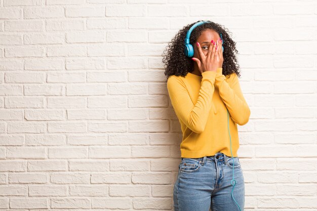 Jeune femme noire se sent inquiète et effrayée, regardant et couvrant le visage, concept de peur et d&#39;anxiété