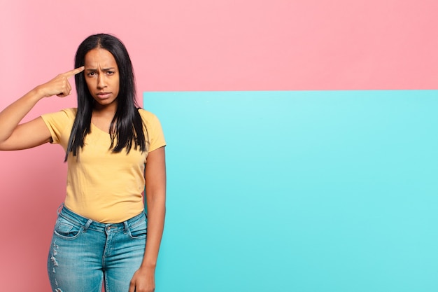 jeune femme noire se sentant confuse et perplexe, montrant que vous êtes fou, fou ou fou. concept d'espace de copie