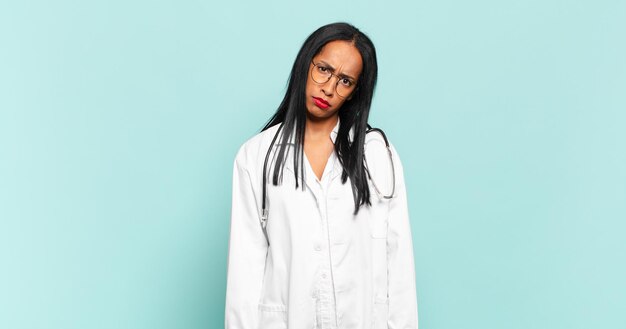 Jeune femme noire se sentant perplexe et confuse avec une expression stupéfaite muette regardant quelque chose de concept de médecin inattendu