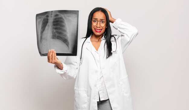 Jeune femme noire se sentant stressée, inquiète, anxieuse ou effrayée, les mains sur la tête, paniquée par erreur. concept de médecin