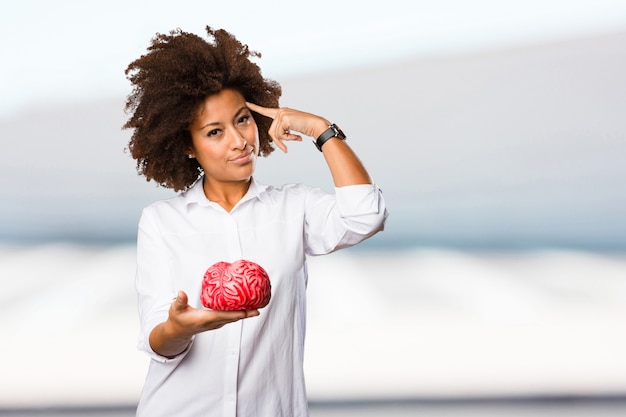 Photo jeune femme noire tenant une forme de cerveau