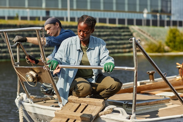 Jeune femme noire travaillant sur le bateau