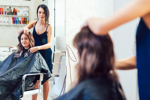 Jeune femme obtenant une belle coiffure dans un salon de coiffure.