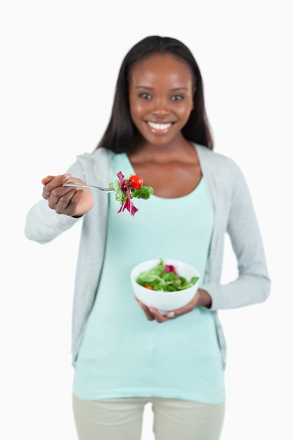 Jeune femme offrant une salade