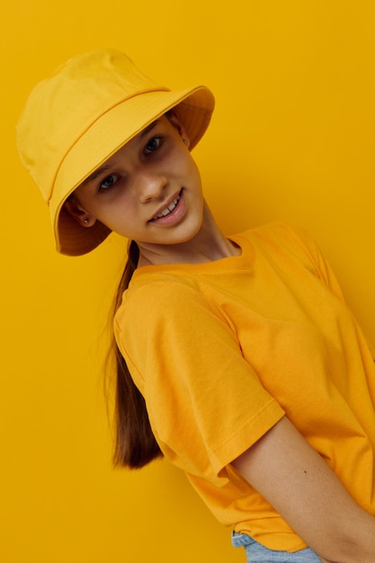 Jeune femme optimiste dans un chapeau jaune vêtements décontractés de style jeunesse fond isolé