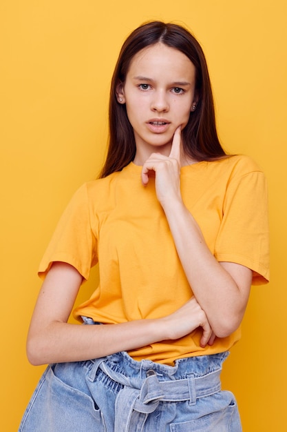 Jeune femme optimiste dans un t-shirt jaune émotions été style fond jaune