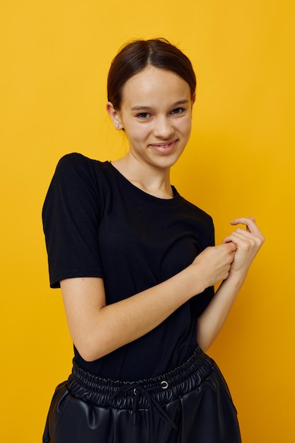 Jeune femme optimiste dans un t-shirt noir et un pantalon sourire fond isolé