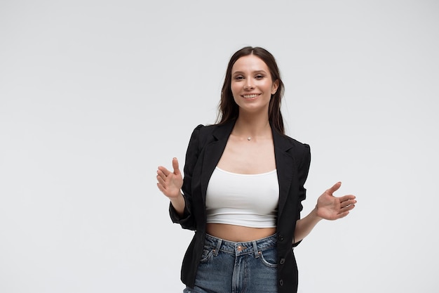 Jeune femme optimiste positive dans des vêtements décontractés faisant des gestes et montrant une grande taille avec les mains