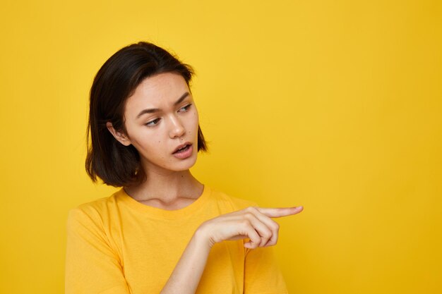 Jeune femme optimiste en t-shirt jaune posant mode de vie inchangée