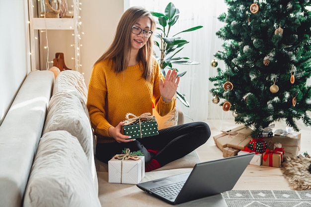 Jeune femme avec ordinateur portable accepte les félicitations en ligne