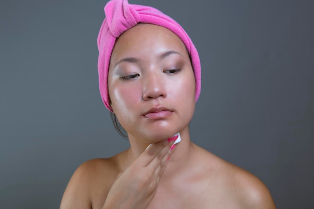 Jeune femme d'origine asiatique nettoyant son visage
