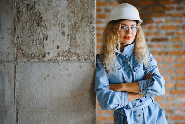 Jeune femme ouvrière avec un casque blanc sur le chantier.