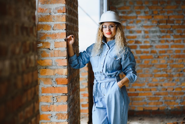 Jeune femme ouvrière avec un casque blanc sur le chantier.