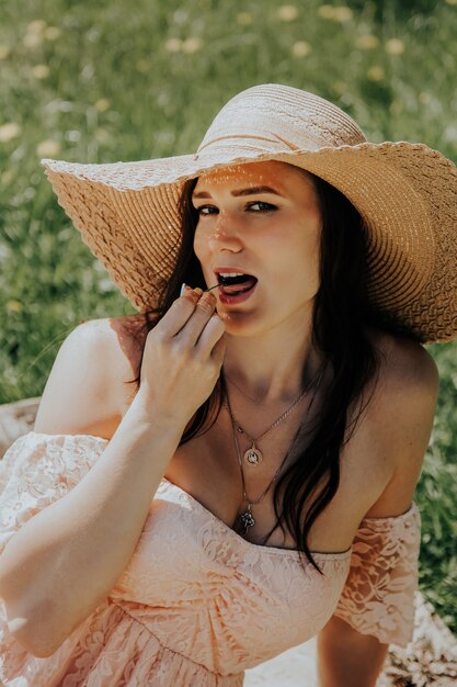 Jeune, femme, paille, chapeau, manger, cerises, Dehors