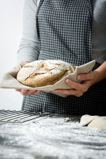 jeune femme avec un pain rustique à la main