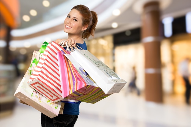 Jeune femme avec panier sur fond flou centre commercial