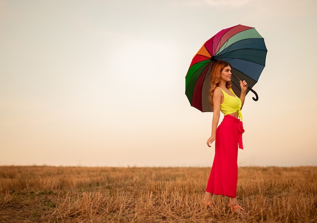 Jeune femme avec parapluie sur le terrain