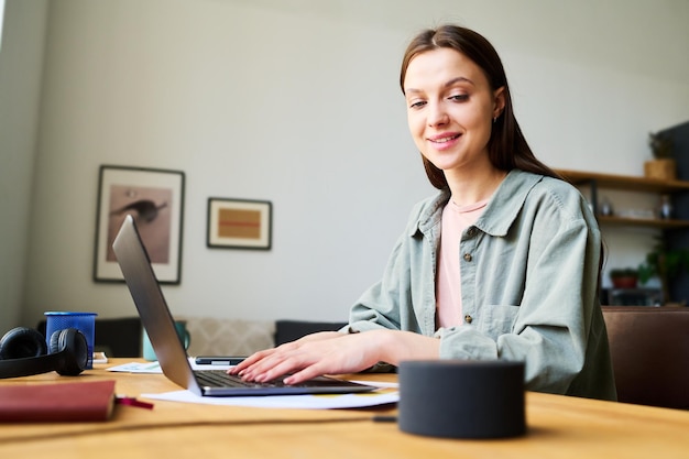 Jeune femme parlant au haut-parleur intelligent