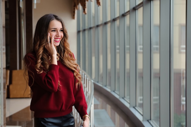 Jeune femme parlant au téléphone à l'aéroport