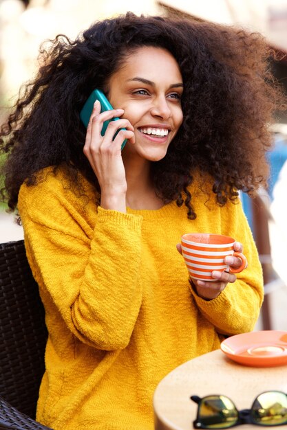 Photo jeune femme parlant au téléphone dans un café