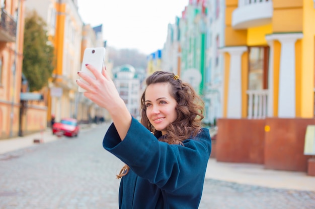 Jeune femme parlant au téléphone, smartphone dans la rue.