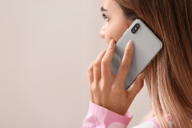 Jeune femme parlant par téléphone mobile dans la chambre