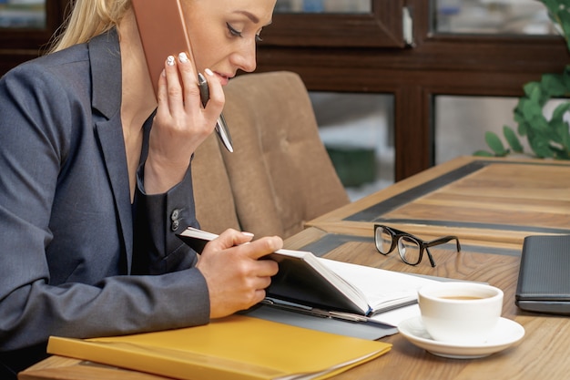 Jeune femme parle par téléphone portable au bureau.