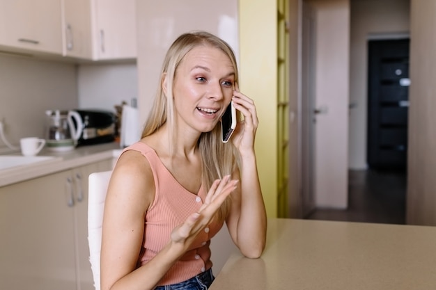 Jeune femme, parler téléphone, chez soi