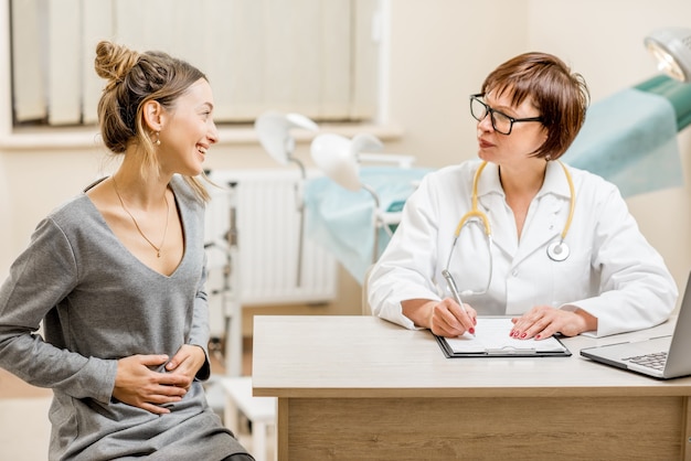 Jeune femme patiente avec un gynécologue senior lors de la consultation au bureau