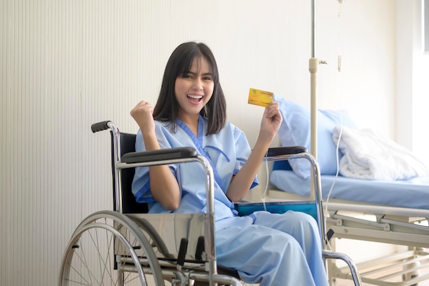 Une jeune femme patiente tient une carte de crédit admettant à l'hôpital Concept de soins de santé