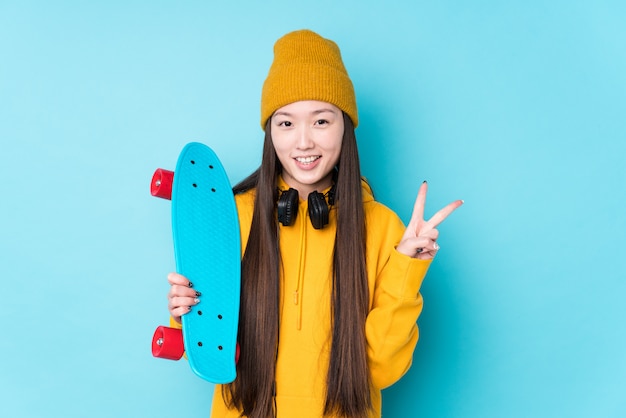 Jeune femme patineuse chinoise montrant le numéro deux avec les doigts.