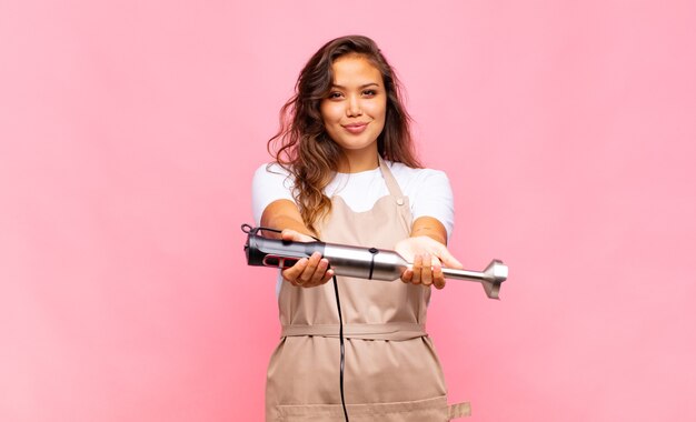 Jeune femme pâtissière se sentant heureuse, excitée, surprise ou choquée, souriante et étonnée de quelque chose d'incroyable