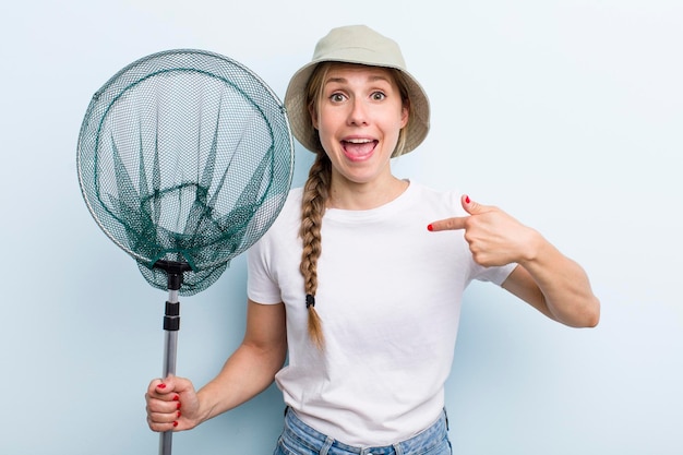 Jeune femme pêcheuse blonde adulte avec un concept net de vacances et de passe-temps