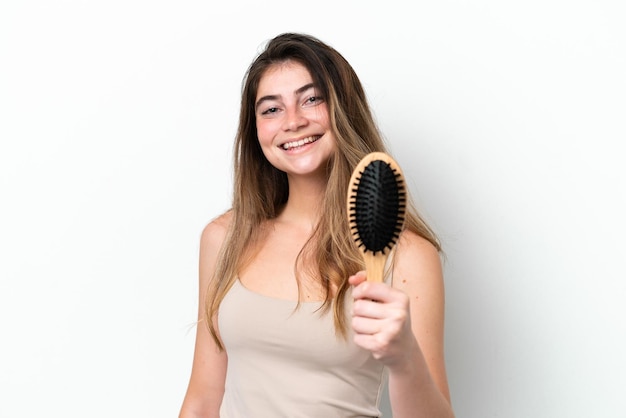 Jeune femme avec un peigne à cheveux isolé sur fond blanc avec une expression heureuse