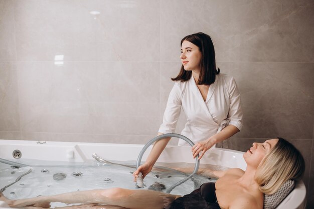 Jeune femme pendant l'hydromassage dans un salon de beauté