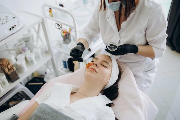 Jeune femme pendant la procédure d'épluchage du visage en gros plan de salon