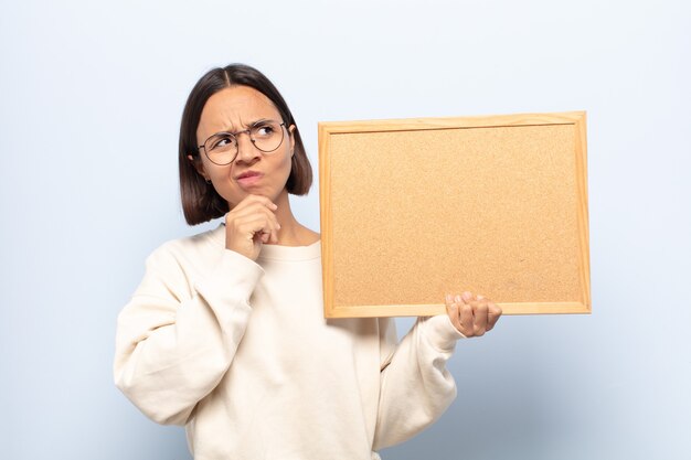 Jeune femme pensant, doutant et confus, avec différentes options, se demandant quelle décision prendre