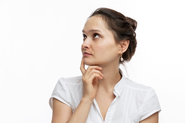 Jeune femme pensive. Jolie brune. Fermer. Fond blanc.