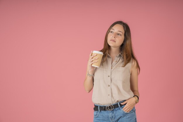 Jeune femme pensive en sirotant une tasse de café