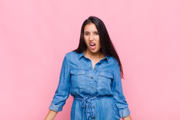 Jeune femme perplexe et confuse, avec une expression stupide et stupéfaite en regardant quelque chose d'inattendu