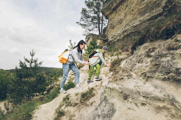 Jeune femme avec un petit garçon en bas âge grimpant sur des rochers