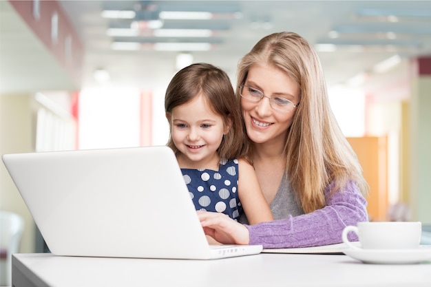 Jeune femme avec petite fille à l'aide d'un ordinateur portable