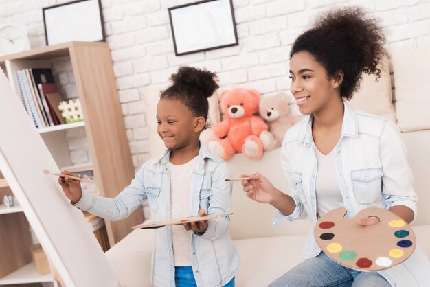 Jeune femme et petite fille dessiner ensemble.