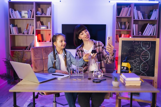 Une jeune femme et une petite fille mignonne tournent une vidéo de leur recherche scientifique.