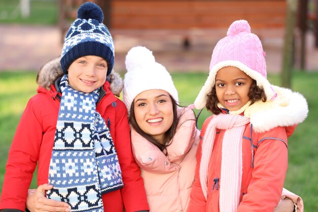 Jeune femme avec de petits enfants à l'extérieur.