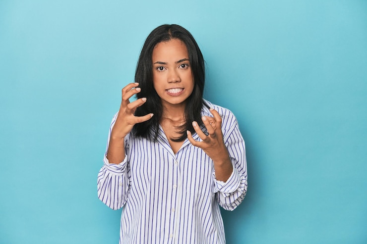 Photo une jeune femme philippine sur le studio bleu en colère criant avec les mains tendues